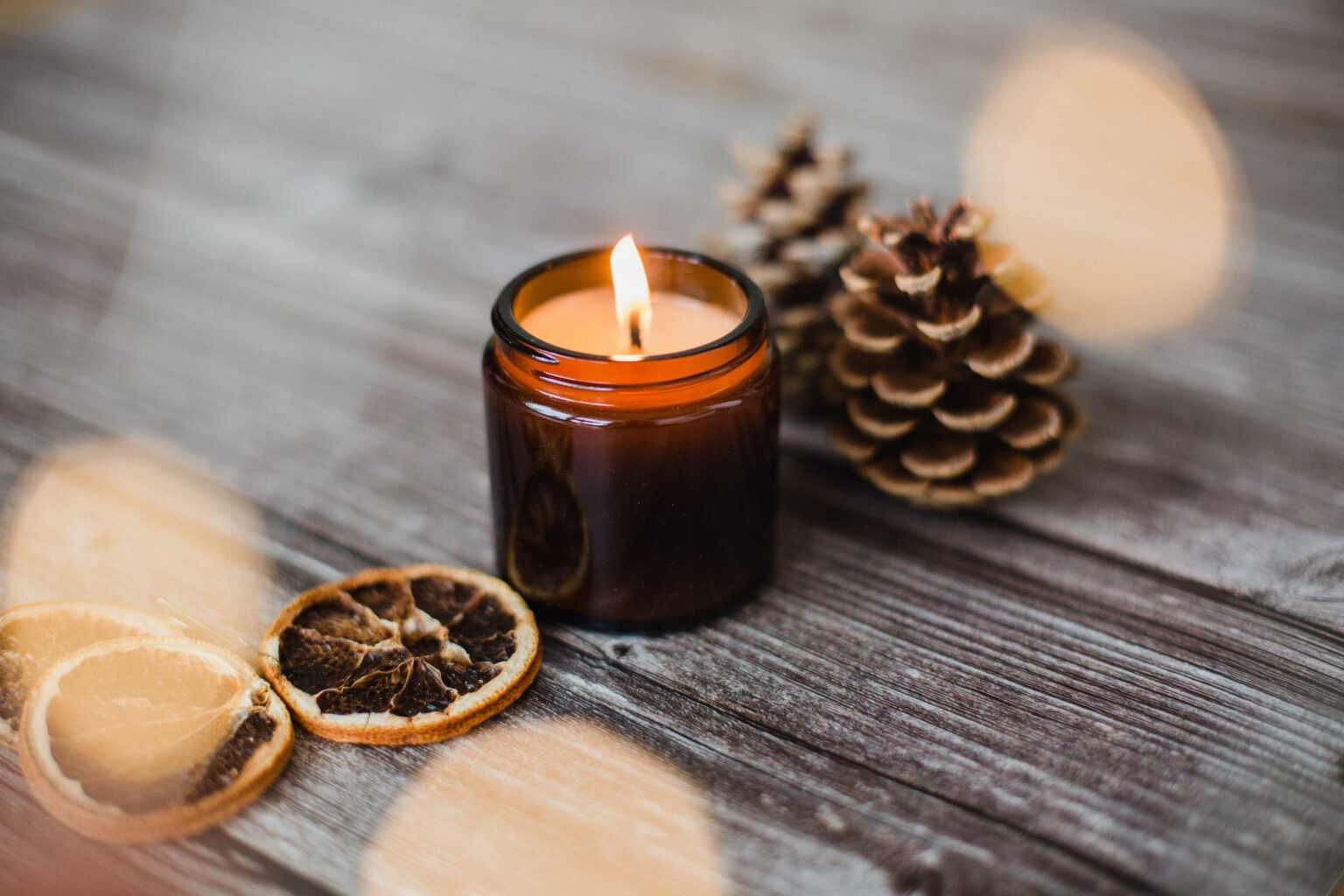 Home layout closeup shot of decorative candles and pine cones