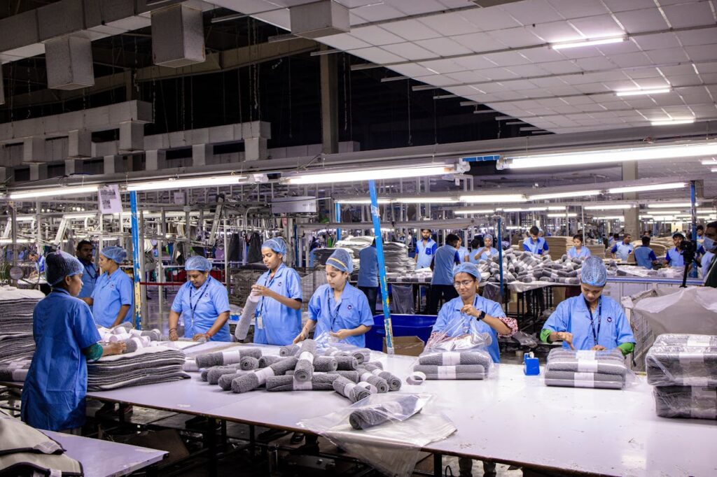 Group of blue collar workers organizing textiles in an Indian factory setting.