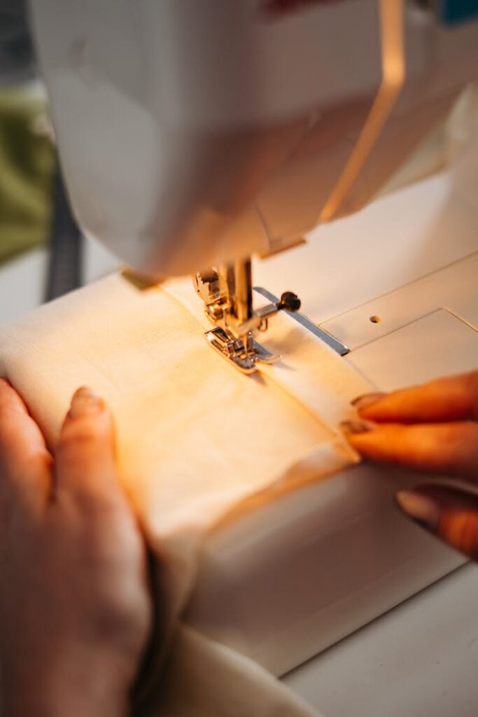 A detailed view of hands sewing fabric on a machine, highlighting craftsmanship.