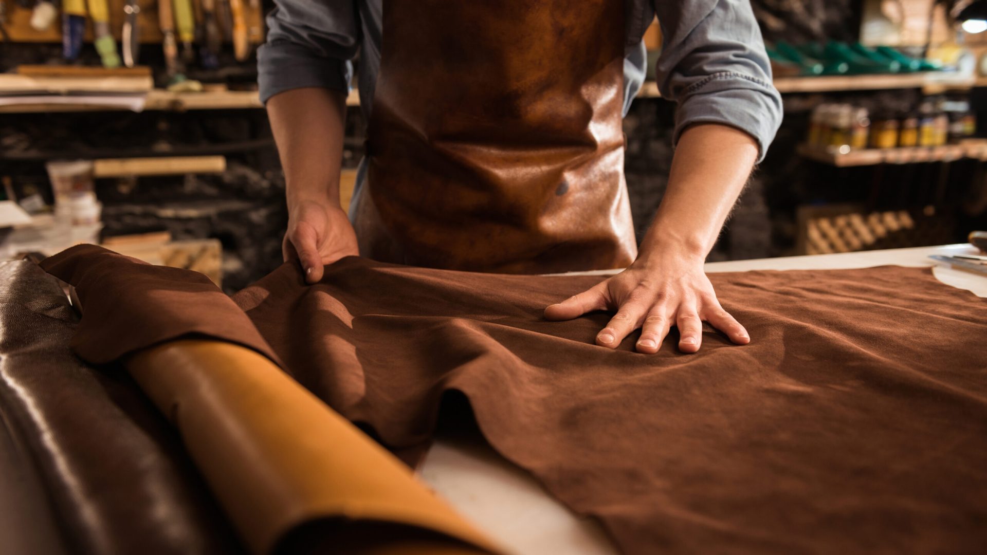 Home layout close up of a cobbler working with leather textile