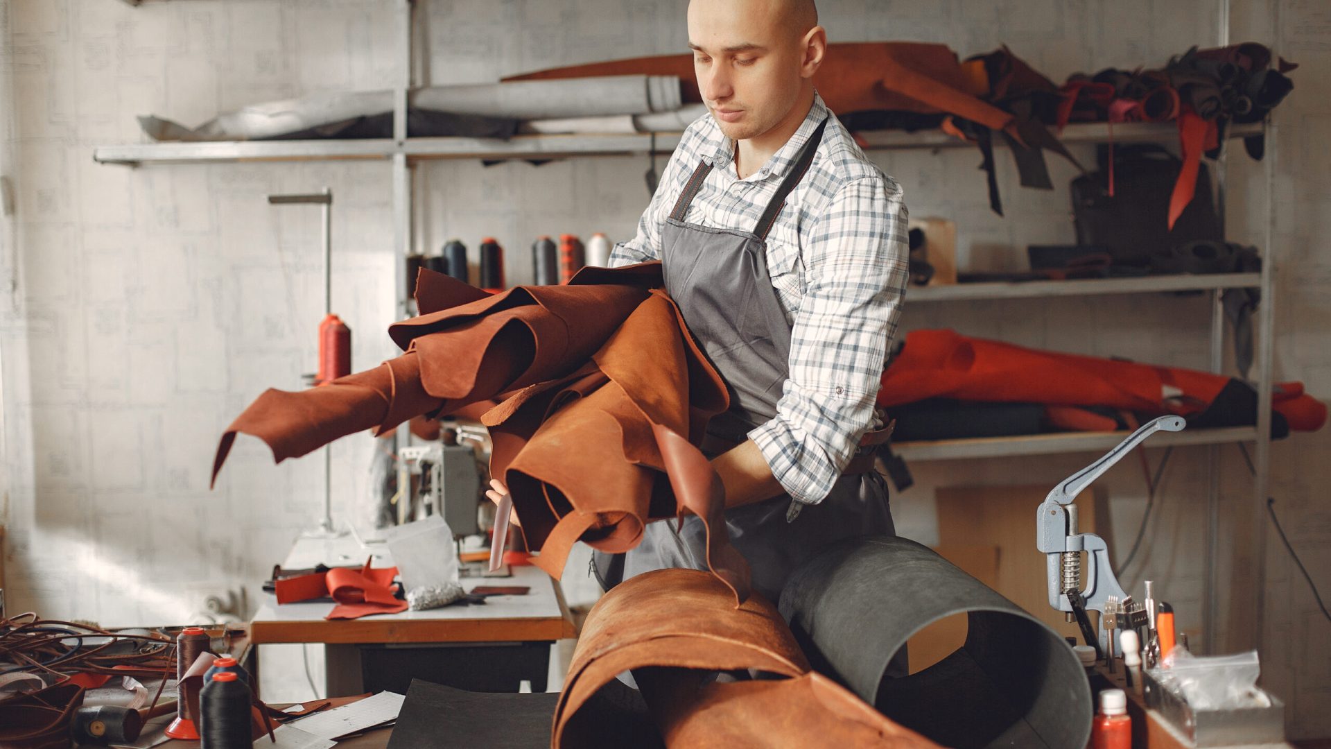 Home layout man in a studio creates leather ware