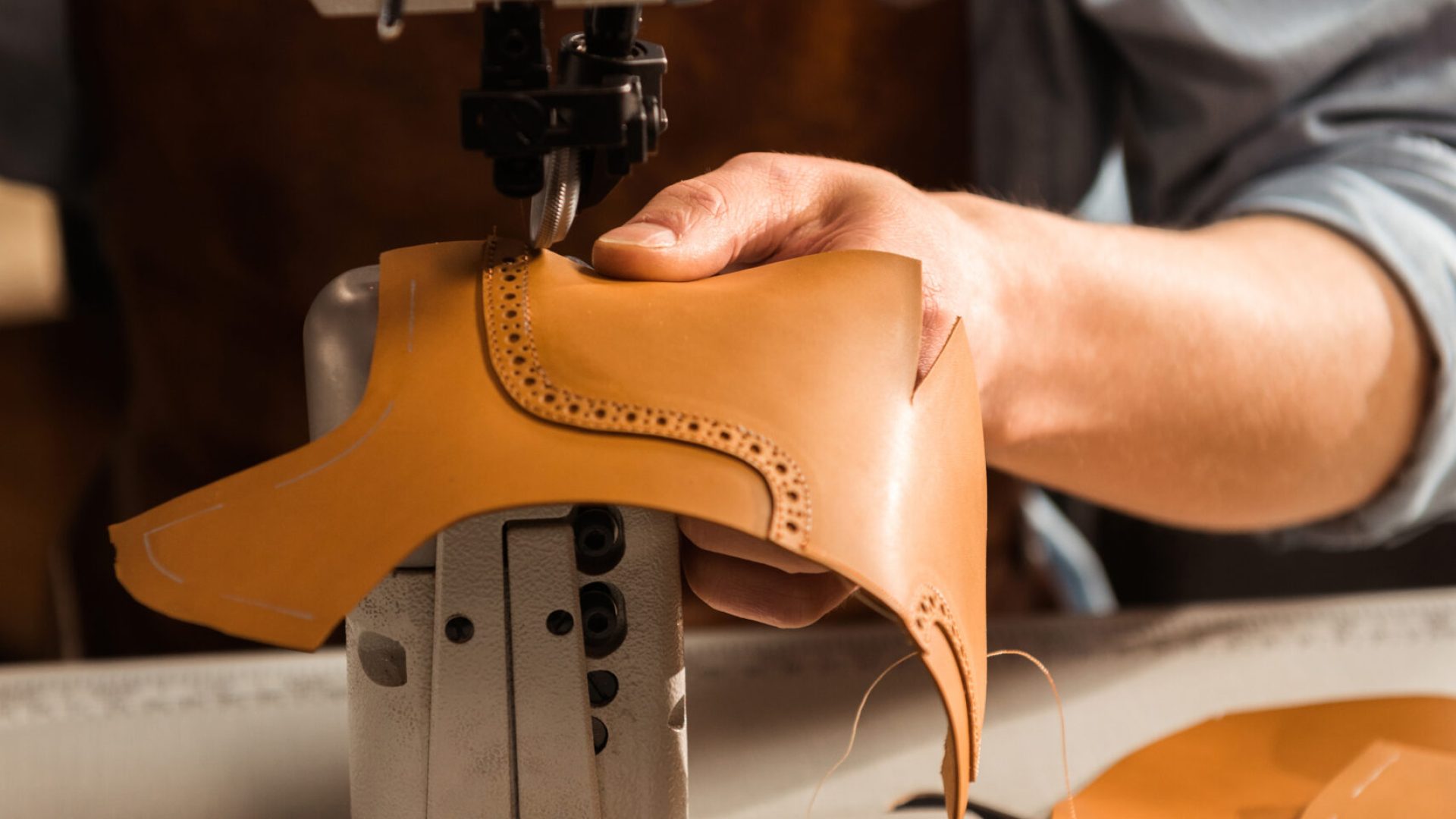 Home layout close up of a shoemaker using sewing machine